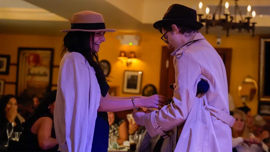 A Murder Mystery Company detective questioning a guest at a Dallas show